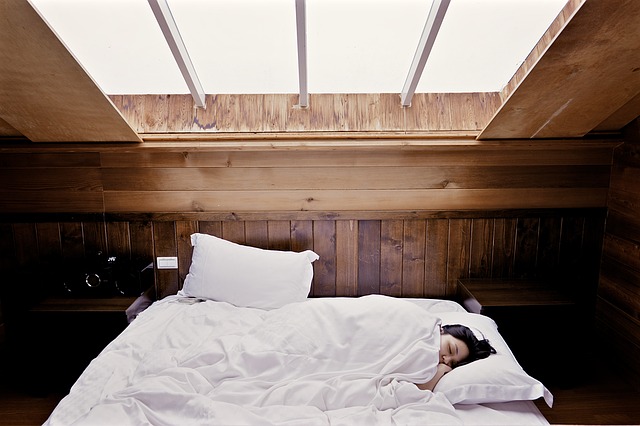 Asiatka na posteli v dřevem obloženém pokoji